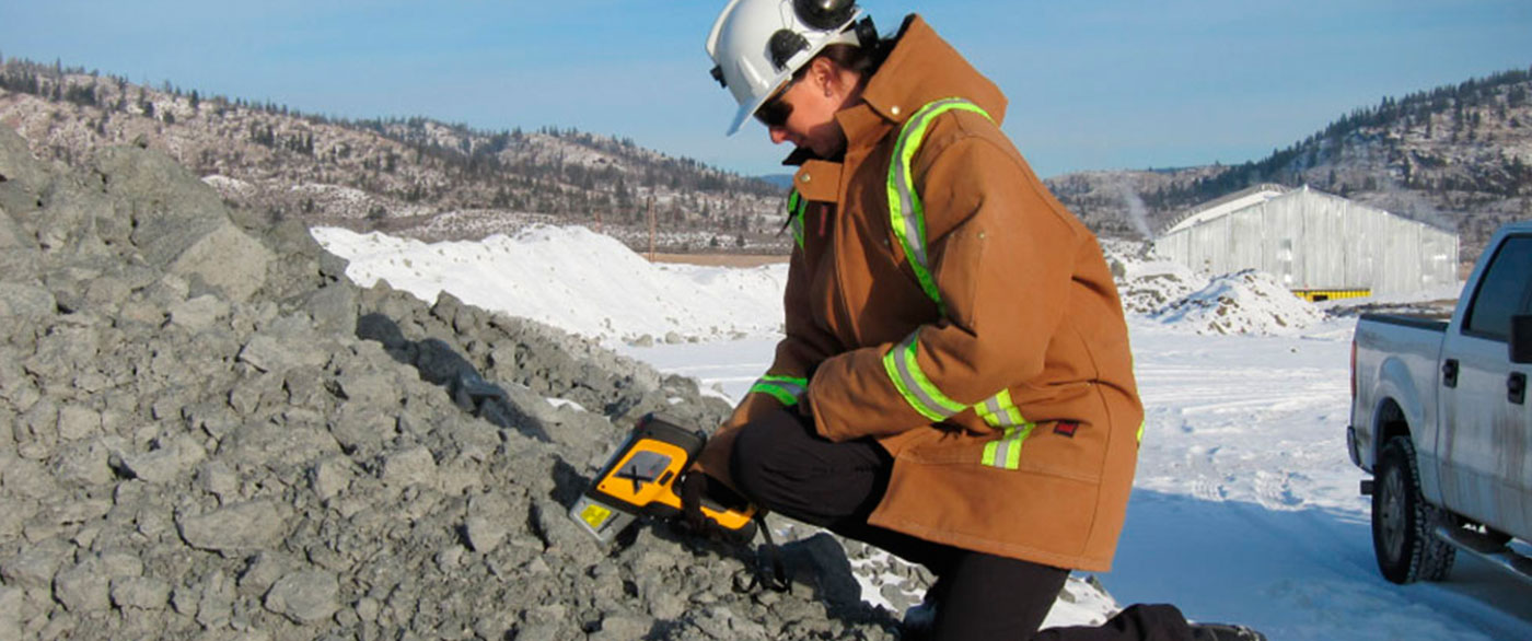 Field tech sampling soil with an XRF analyzer